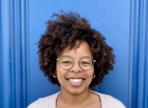 Kela Caldwell headshot in front of blue background