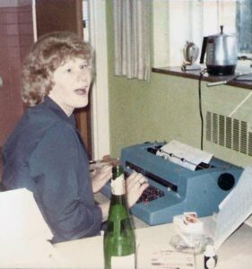 Lynn Sullivan seated at her typewriter at UHS in 1970s.